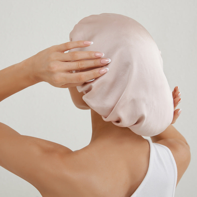 Donna che indossa cuffia per capelli in seta rosa cipria