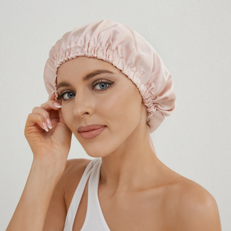 Donna che indossa cuffia per capelli in seta rosa cipria