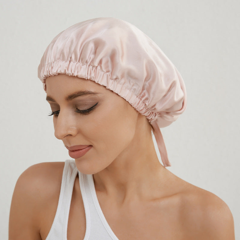 Donna che indossa cuffia per capelli in seta rosa cipria