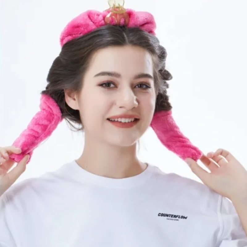 Donna sorridente che applica bigodini senza calore rosa BellaSeta per ottenere ricci naturali