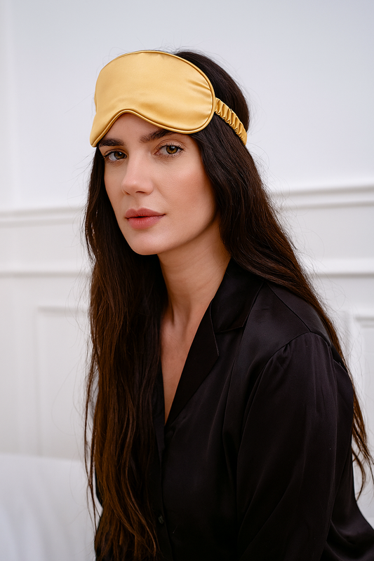 Donna con mascherina per dormire in seta gialla, accessorio elegante per il sonno ristoratore