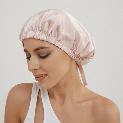 Donna che indossa cuffia per capelli in seta rosa cipria
