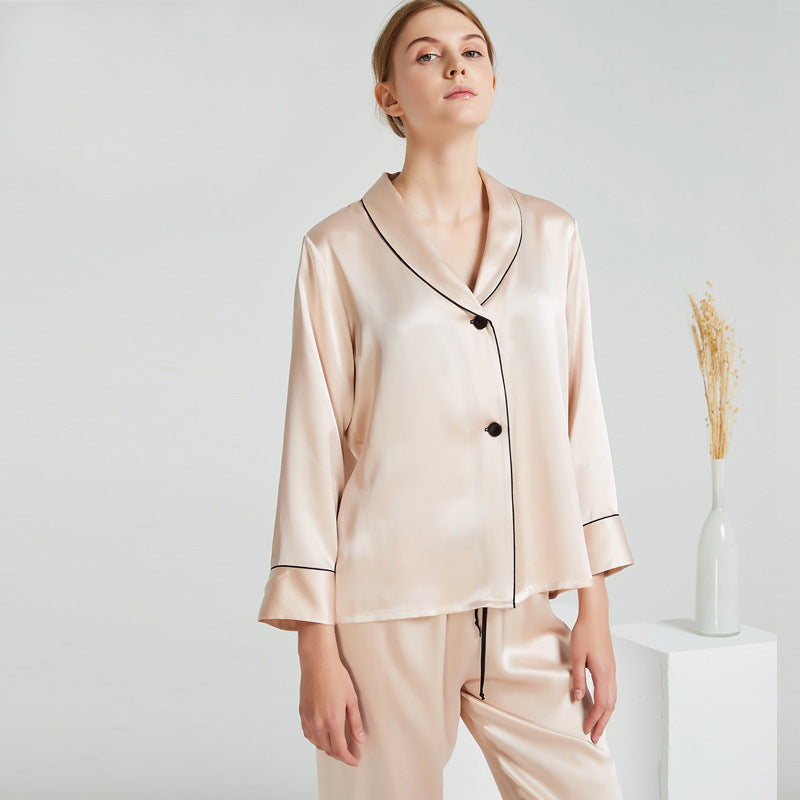 Donna che indossa pigiama in seta beige due pezzi con camicia a maniche lunghe e pantaloni Bella Seta