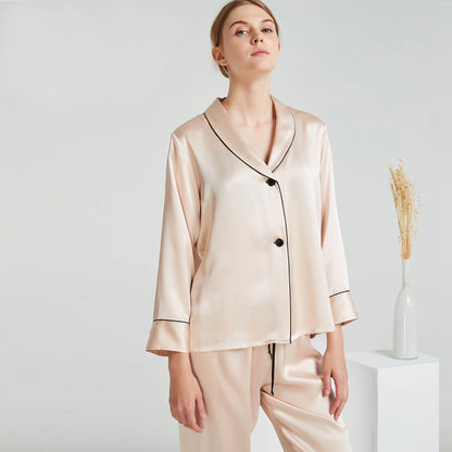 Donna che indossa pigiama in seta beige due pezzi con camicia a maniche lunghe e pantaloni Bella Seta
