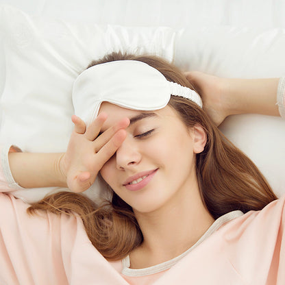Donna con mascherina per dormire in seta bianca, indossata comodamente per un riposo rilassante