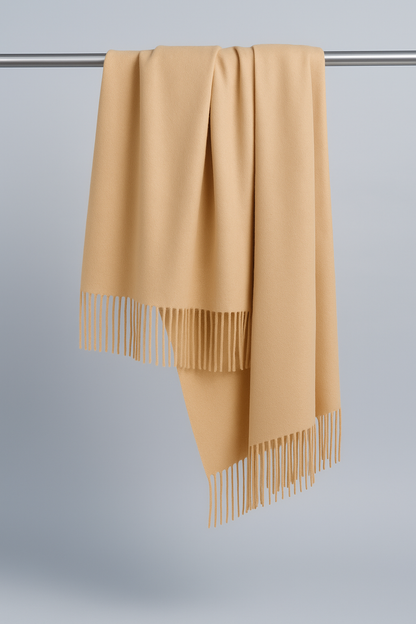 Sciarpa in puro cashmere color cammello con frange, fotografata su sfondo neutro con luce naturale – Bella Seta.